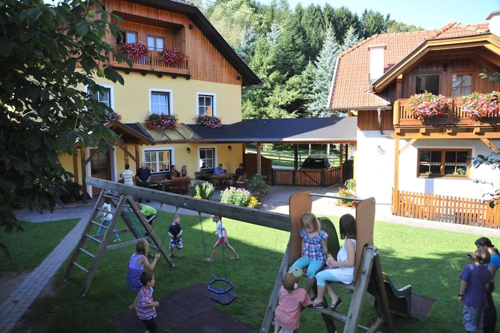 een groep kinderen die in de tuin van een huis spelen bij Ferienwohnungen Simonbauer in Trebesing