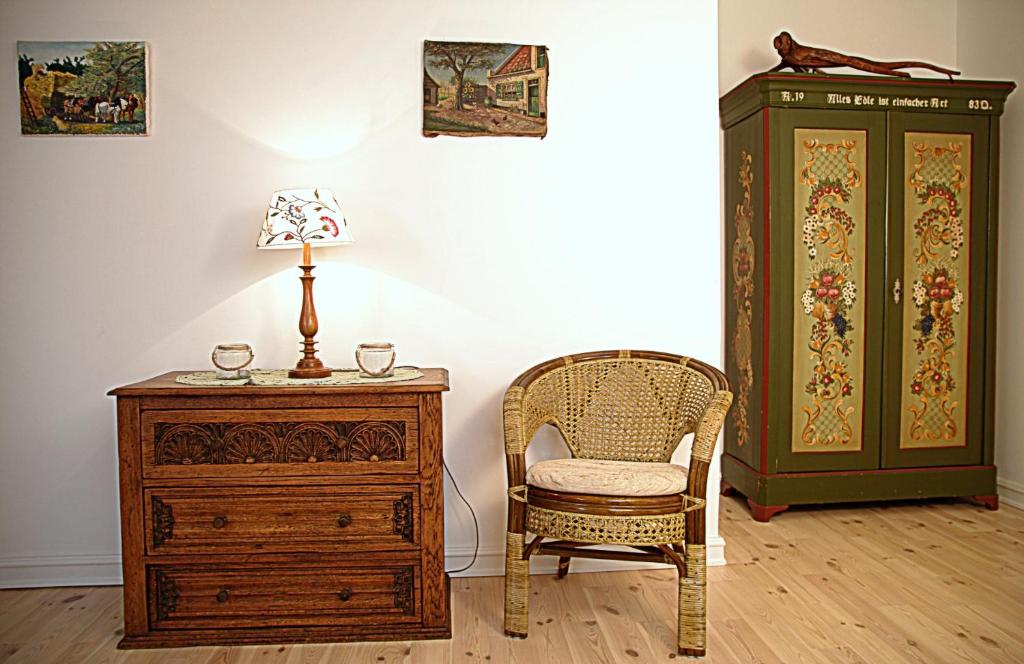 um quarto com uma cadeira, uma cómoda e um candeeiro em Dom pod Skrzydłami em Gawliki Wielkie