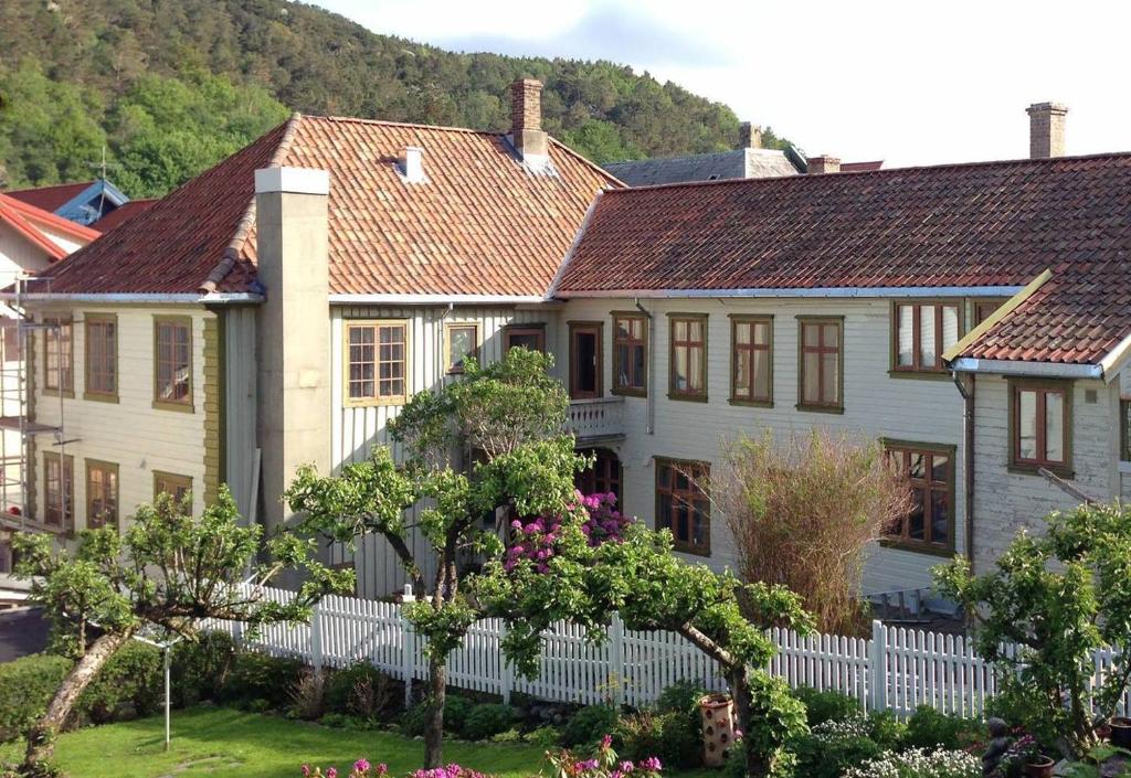 a house with a white fence and trees at Ellingsens Apartment Egersund in Egersund