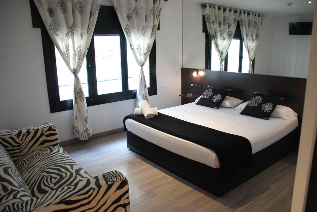 a bedroom with a large bed and a zebra chair at Hotel Casita Amarilla in Barcelona