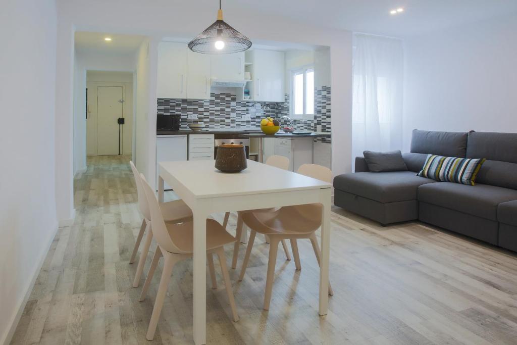 una cucina e un soggiorno con tavolo e sedie bianchi di Apartment Meraki Valencia a Valencia