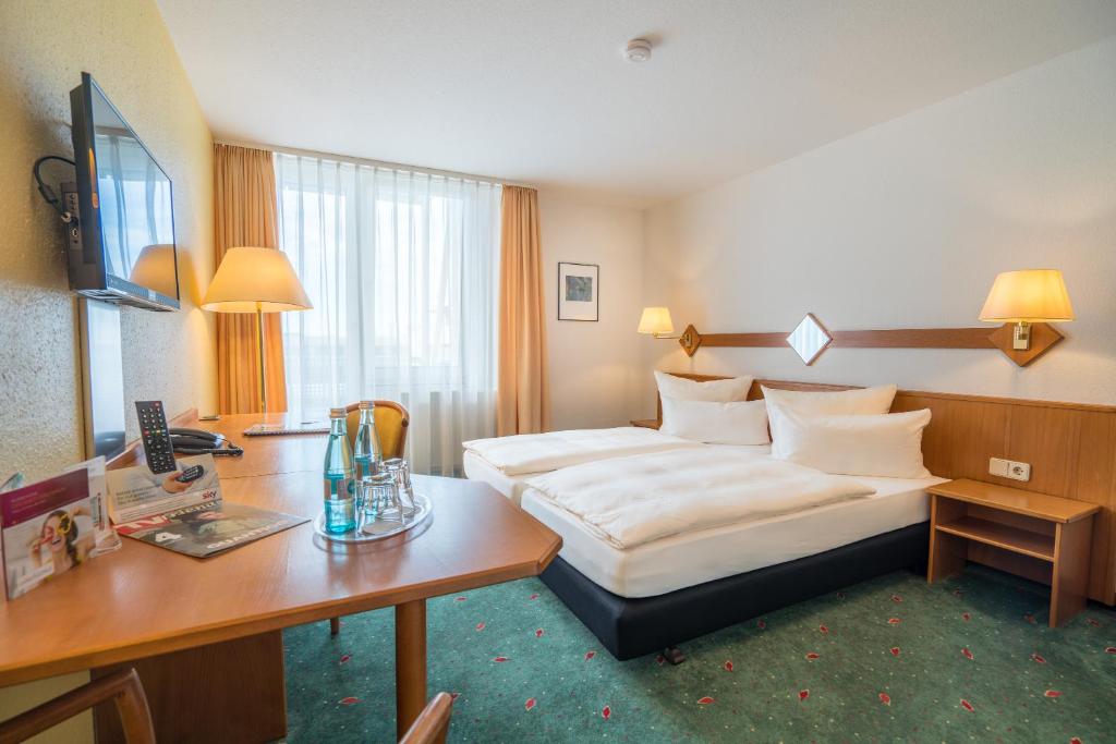 ein Hotelzimmer mit einem Bett und einem Schreibtisch in der Unterkunft Apartmenthotel Residenz Steinenbronn in Steinenbronn
