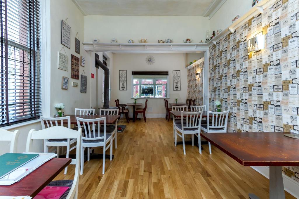 a restaurant with wooden tables and chairs and a dining room at Brecks Hotel in Blackpool