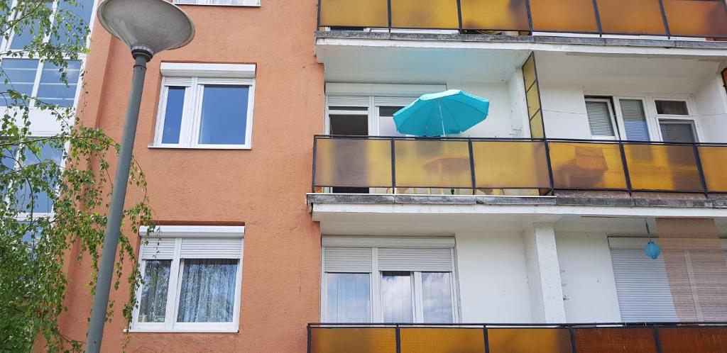 un ombrello blu sul balcone di un edificio di Veszprem Kucko a Veszprém