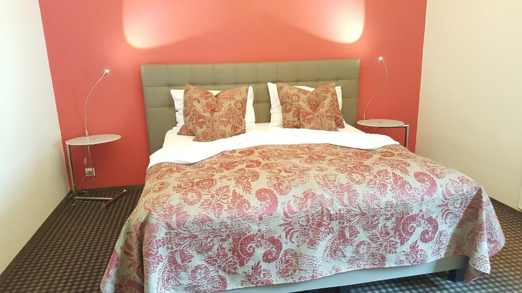グントラムスドルフにあるランドホテル ヤークトホフの赤い壁のベッドルーム1室(大型ベッド1台付)