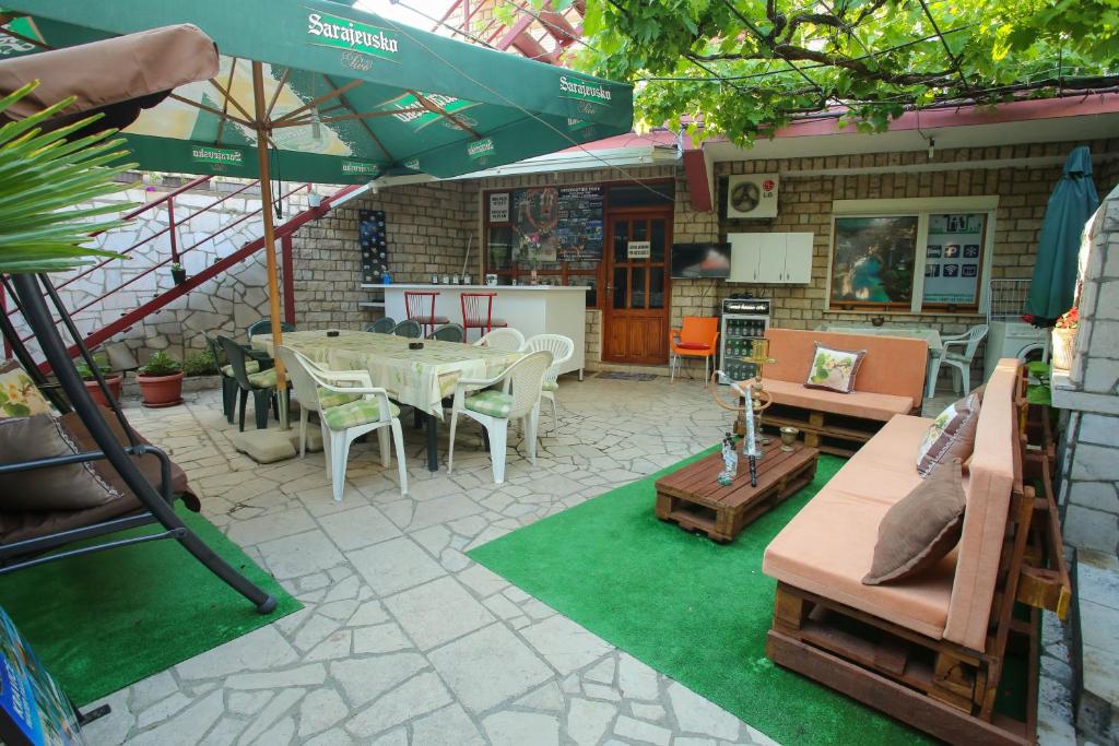 a patio with a table and chairs and an umbrella at Guesthouse Adi in Mostar