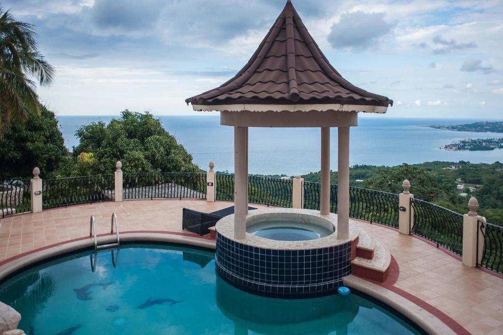 a swimming pool with a gazebo at Clarridge View Guesthouse in Montego Bay