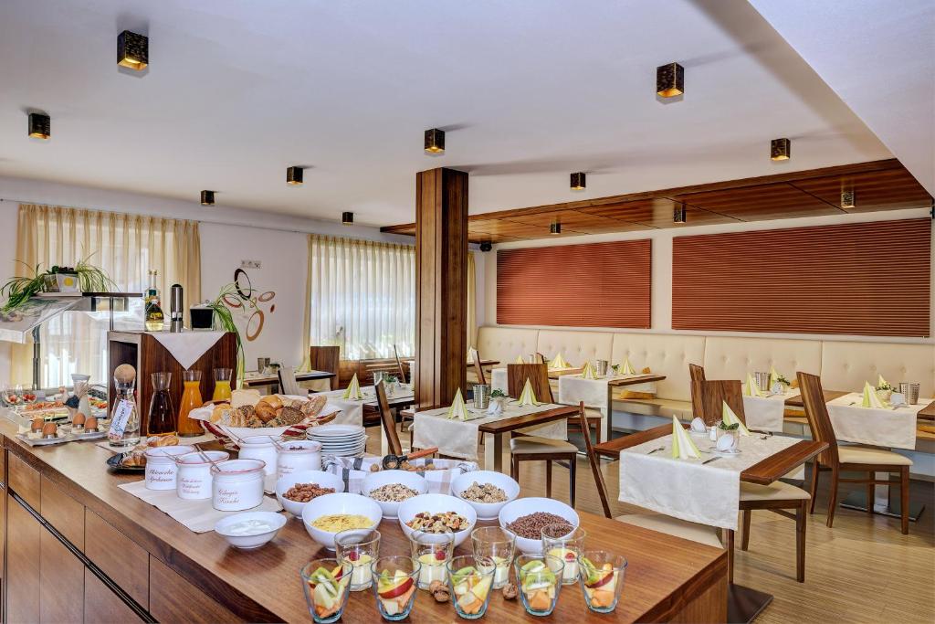 uma sala de jantar com uma mesa com pratos de comida em Garni Apparthotel St Valentin em San Valentino alla Muta