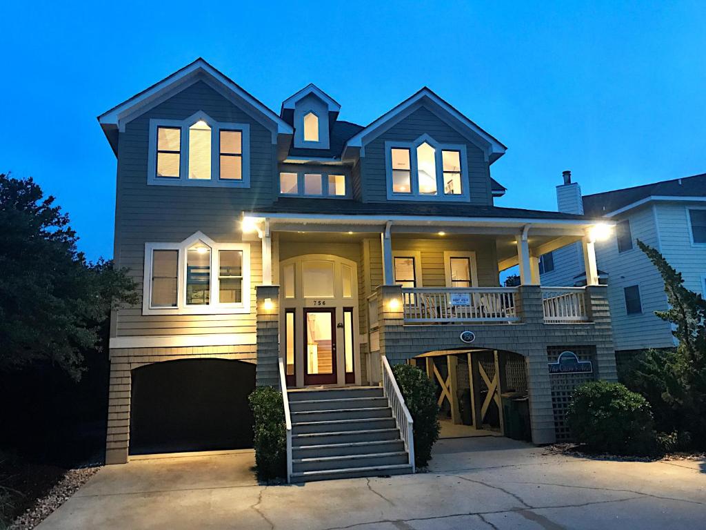 a house with lights on the front of it at Crow's Nest - Corolla, Crown Point, 150 Yds to Beach, Hot Tub, Community Pool, Pets OK in Corolla
