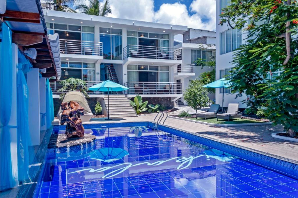 a swimming pool in front of a building at Ikala Galapagos Hotel in Puerto Ayora