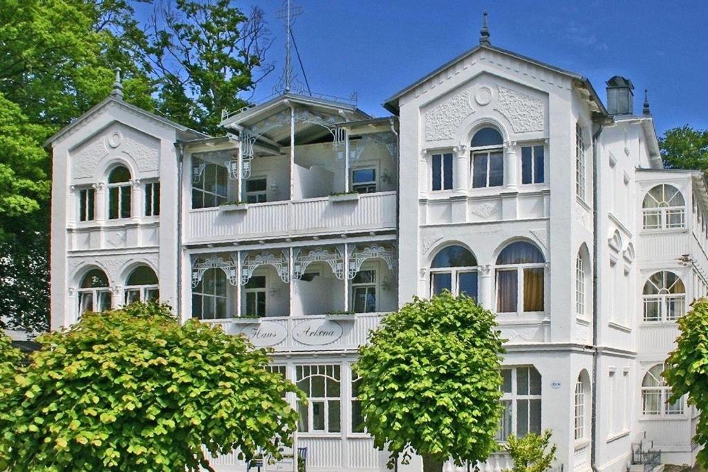 a white building with trees in front of it at Ferienappartement-Moenchgut-14 in Ostseebad Sellin