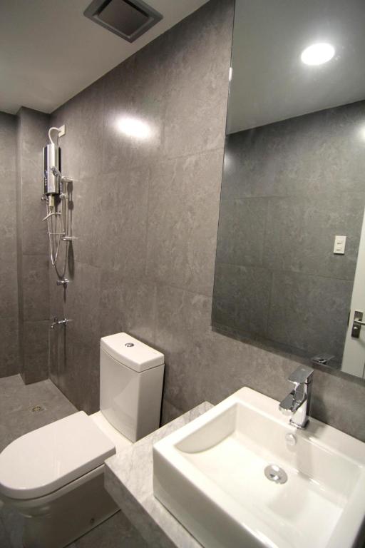 un bagno con lavandino, water e specchio di Z Pad Residences a Tacloban