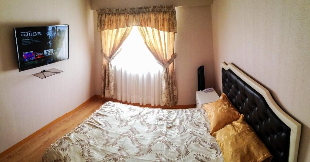 een slaapkamer met een bed voor een raam bij Vista Ashul Apartment 02 dormitorios in Lima