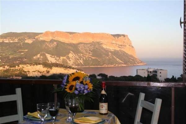 einen Tisch mit einer Flasche Wein und Blumen darauf in der Unterkunft Cassis, perle de la Méditerranée in Cassis