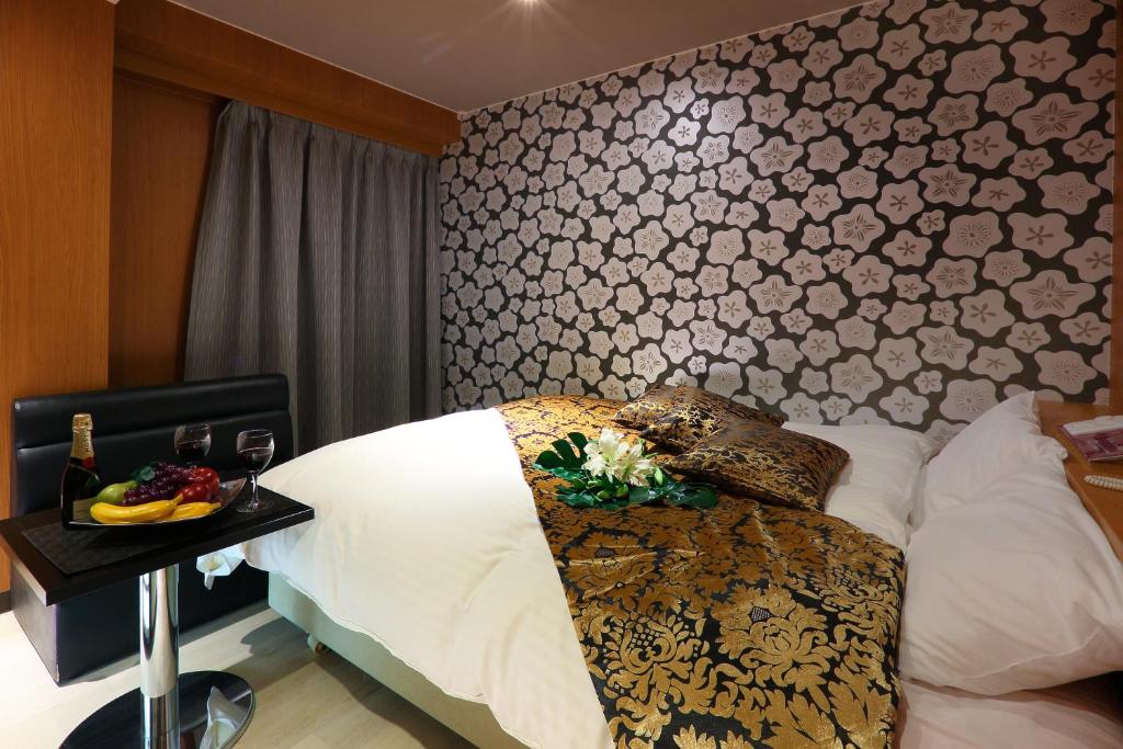 a bedroom with a bed and a table with a tray of fruit at HOTEL le bordeaux -ル ボルドー- in Kurume