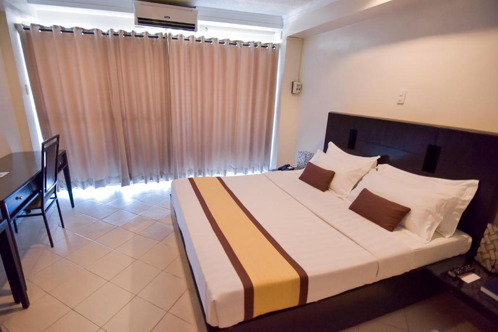 Postel nebo postele na pokoji v ubytování Hotel Tavern Surigao