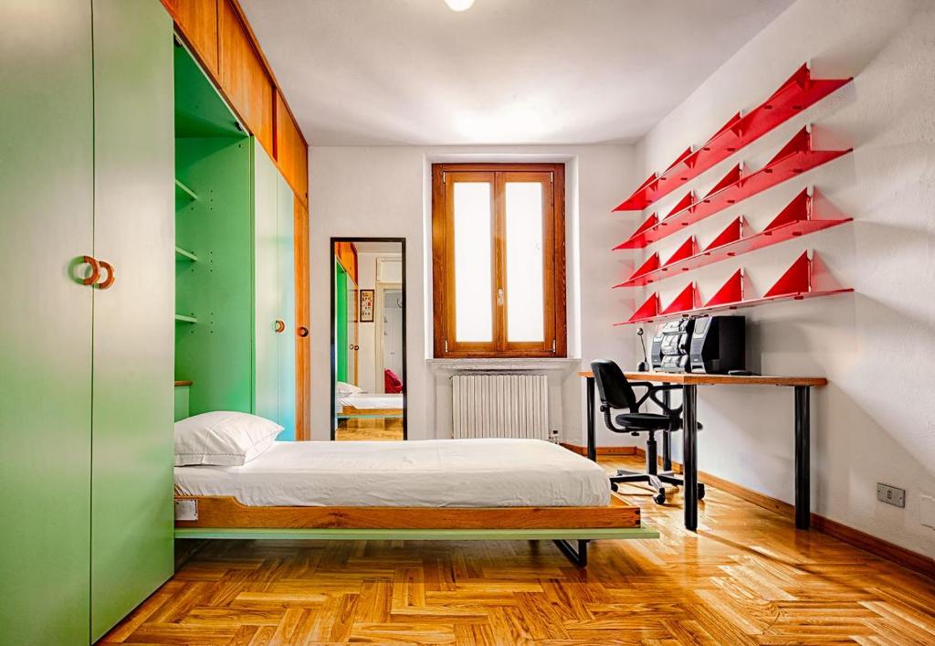 a bedroom with a bed and a desk with a computer at Duomo-City Life In The Heart Of The City! in Milan