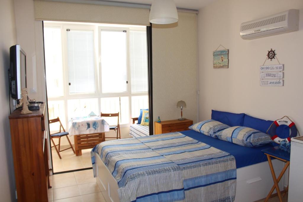 1 dormitorio con cama y ventana grande en Montehugh, en Lárnaca