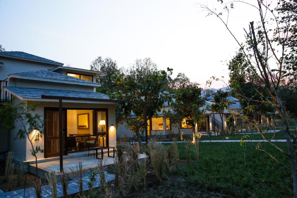 a house with a patio and a yard at Saraca Resort & Spa Corbett in Garjia