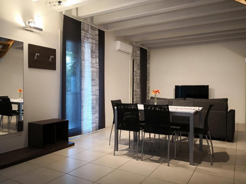 a dining room with a table and chairs and a couch at Villa Zen Apartment in Padova