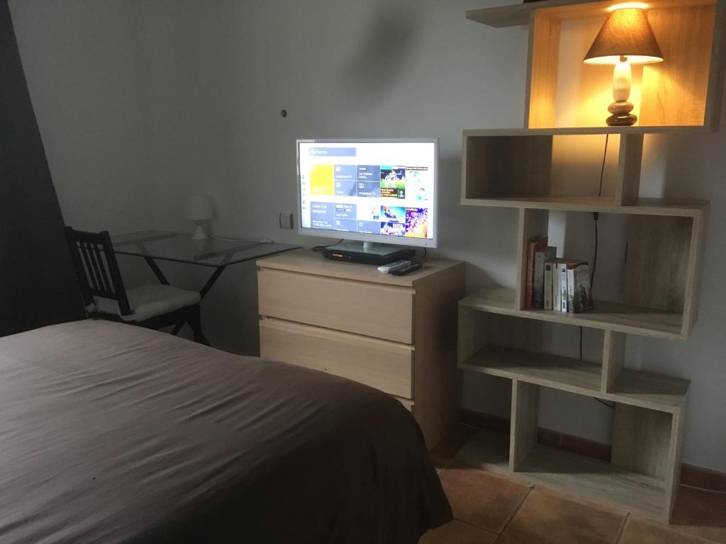 - une chambre avec un lit et une télévision sur une commode dans l'établissement Chambre dans une villa, à Beaupuy