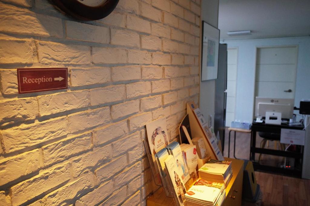 een kamer met een bakstenen muur met dozen ertegenaan bij YaKorea Hostel Gangnam in Seoul