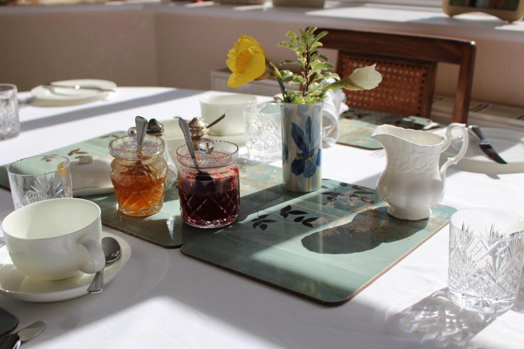 uma mesa com uma bandeja verde com bebidas em Honey Lodge em Broadstone