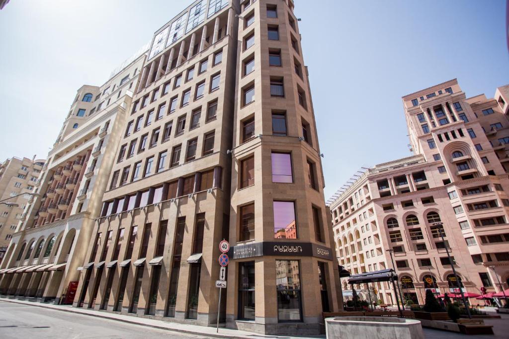 a tall building on a city street with tall buildings at North Avenue Modern Apartments in Yerevan