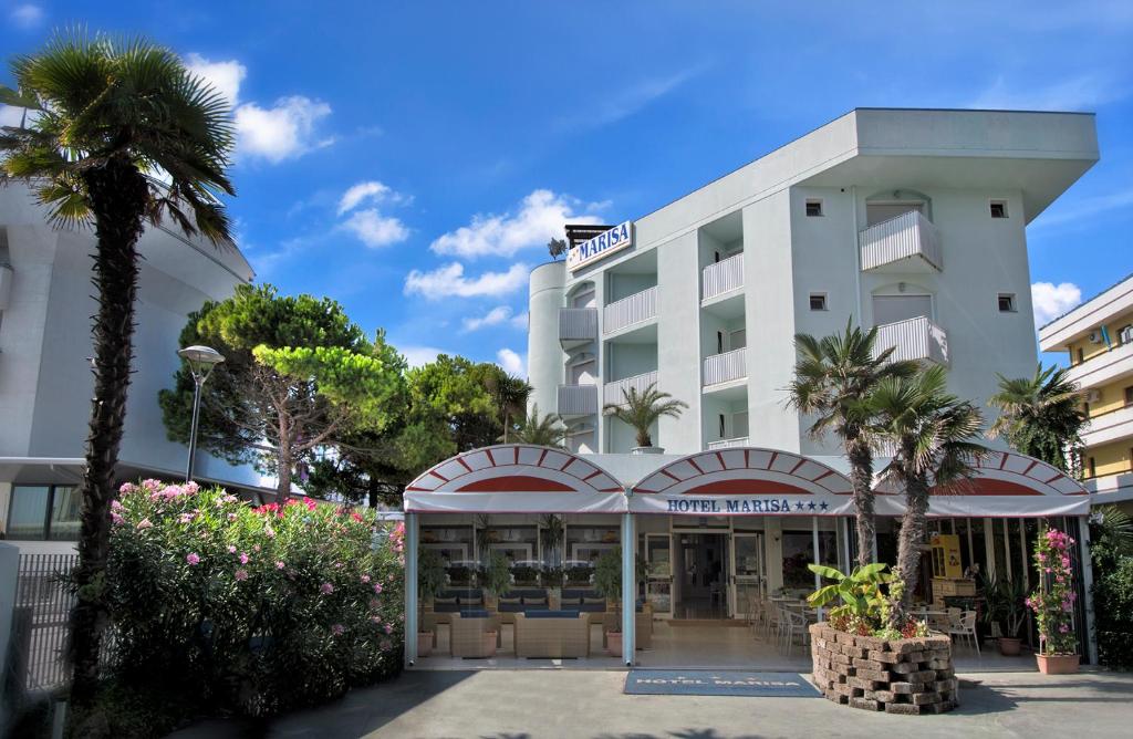 un hôtel avec un palmier en face dans l'établissement Hotel Marisa, à Caorle