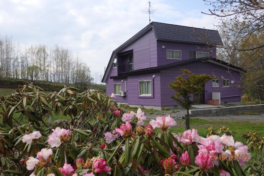 a purple house with flowers in front of it at Cottage CLOVER in Biei