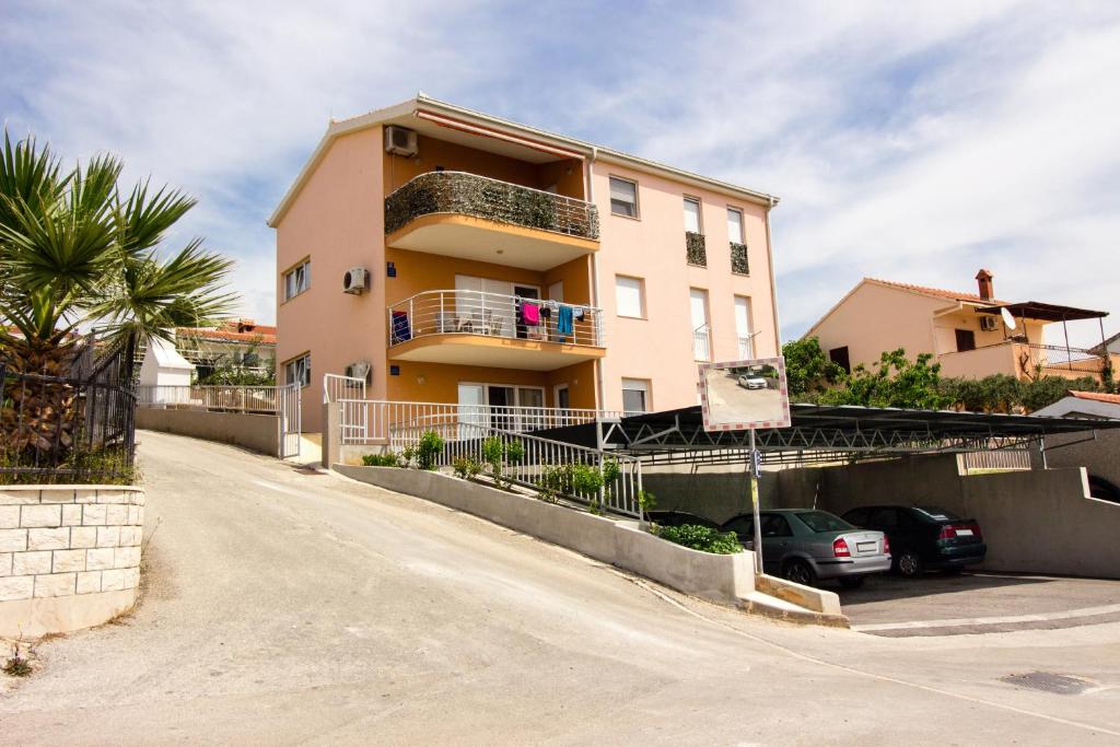 ein Gebäude mit einem davor geparkten Auto in der Unterkunft Apartment Jusepe in Trogir
