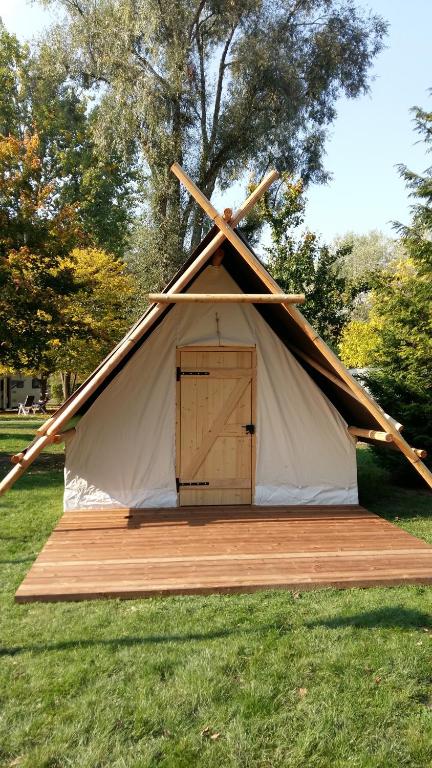 a teepee tent with a door in the grass at Camping Du Port De Plaisance in Péronne