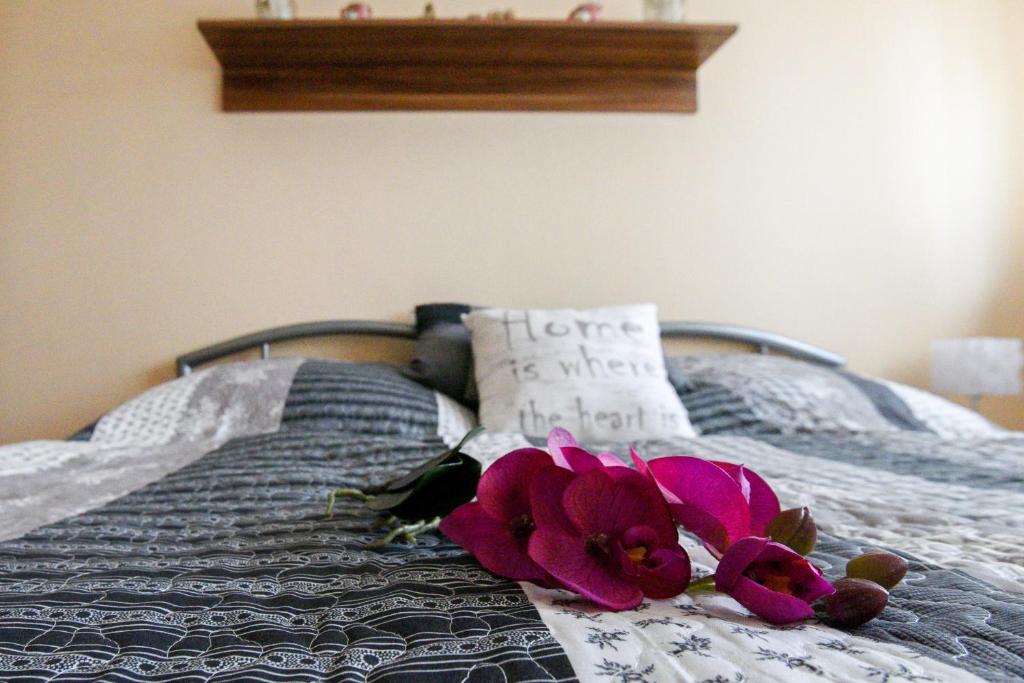 un letto con due fiori rosa sopra di Rózsa Völgy Apartman a Eger