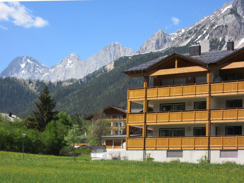 um grande edifício com montanhas ao fundo em Apartment Coley em Ramsau am Dachstein