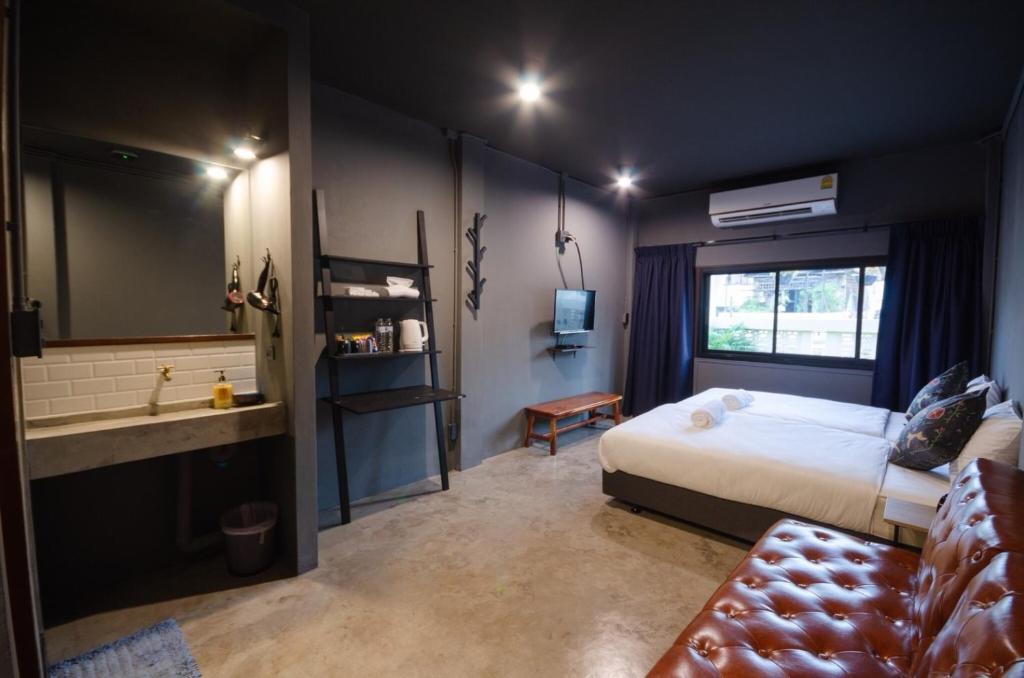 a bedroom with a bed and a bathroom with a sink at Tian Tian Hostel in Bangkok