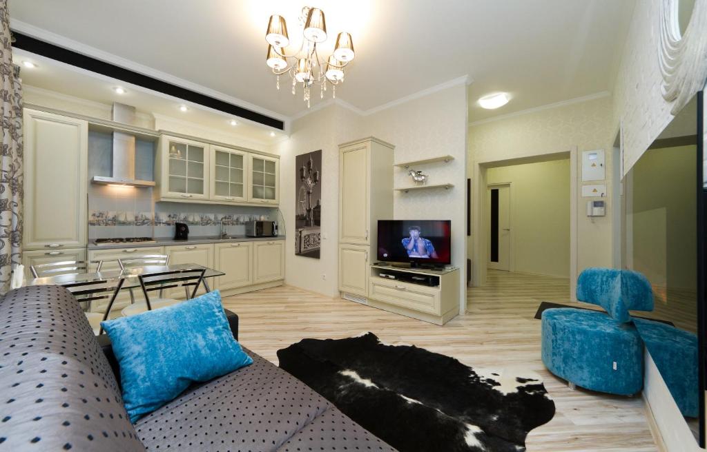 ein Wohnzimmer mit einem Sofa und einem TV in der Unterkunft Апартаменты на Бассейной in Kiew