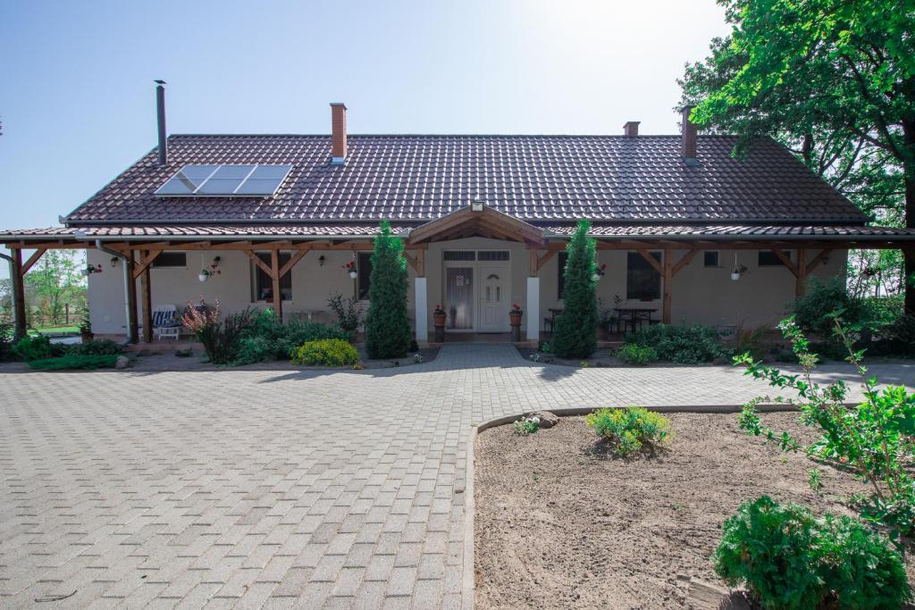 a house with a tile roof and a patio at Tölgyfa Vendégház in Kiskőrös