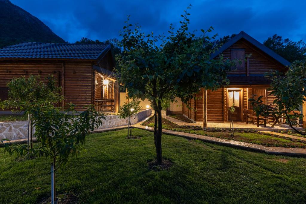 a house with a tree in the yard at Ethno Lodge AB in Virpazar