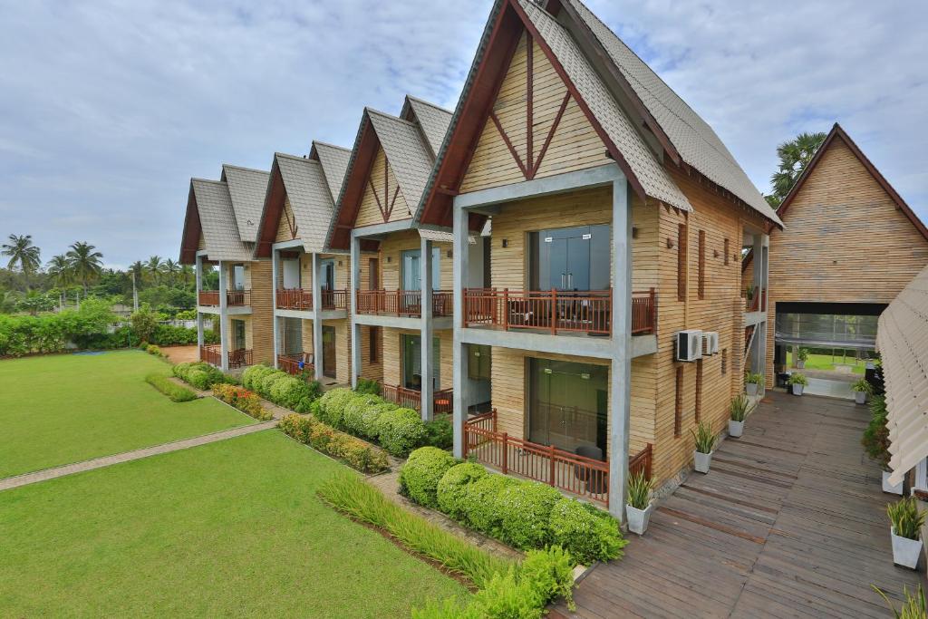 a row of houses with balconies on a lawn at Laya Waves in Pasikuda