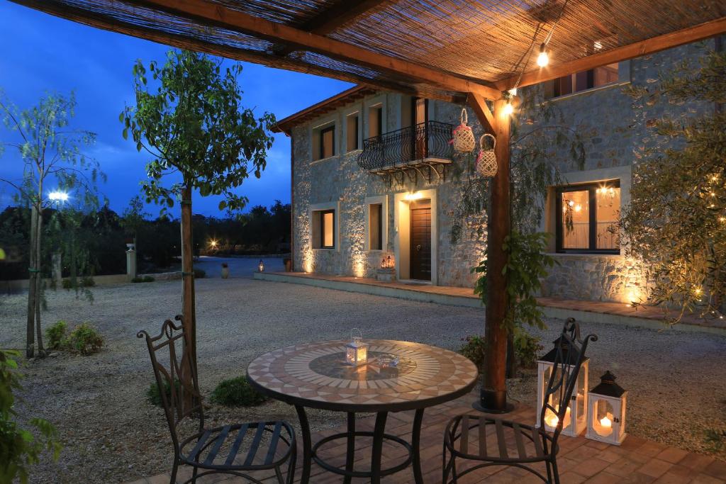 Sonnino的住宿－Casale Madeccia，房屋前设有带桌椅的天井。