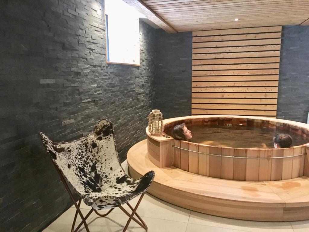 Appart'Hotel Aiguille Verte & Spa في شامونيه مون بلان: كرسي وحوض استحمام في الغرفة