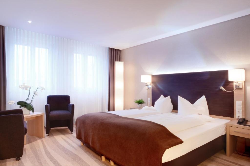 Ein Bett oder Betten in einem Zimmer der Unterkunft Ringhotel Loew's Merkur