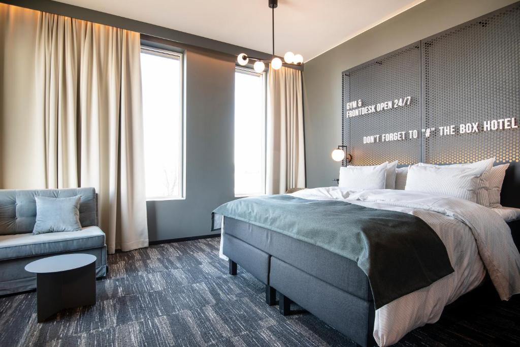 um quarto com uma cama grande e uma cadeira em Quality Hotel The Box em Linköping