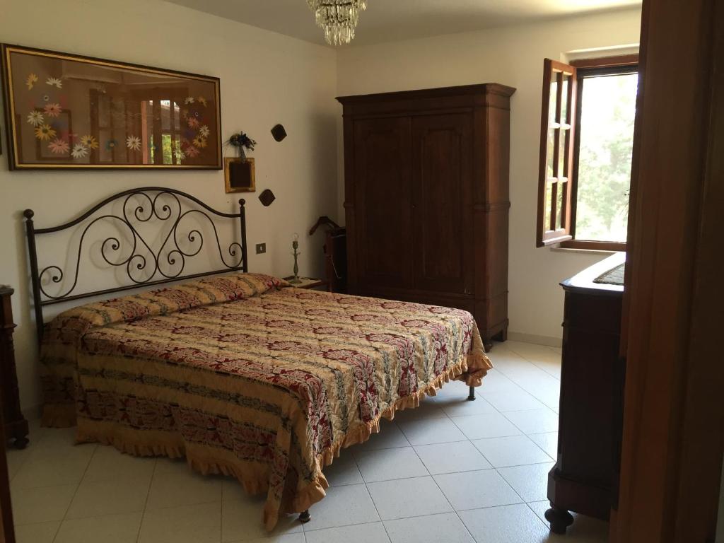 ein Schlafzimmer mit einem Bett, einer Kommode und einem Fenster in der Unterkunft Chia - Casa Margherita in Chia