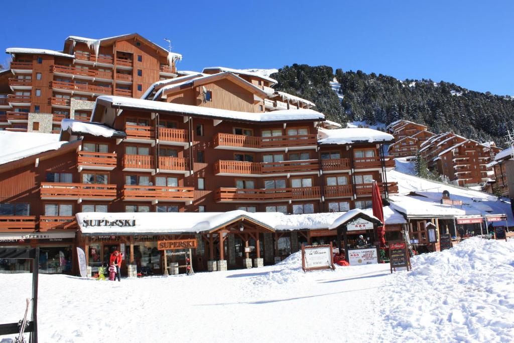 a large ski lodge with snow on the ground at CMD Méribel in Méribel