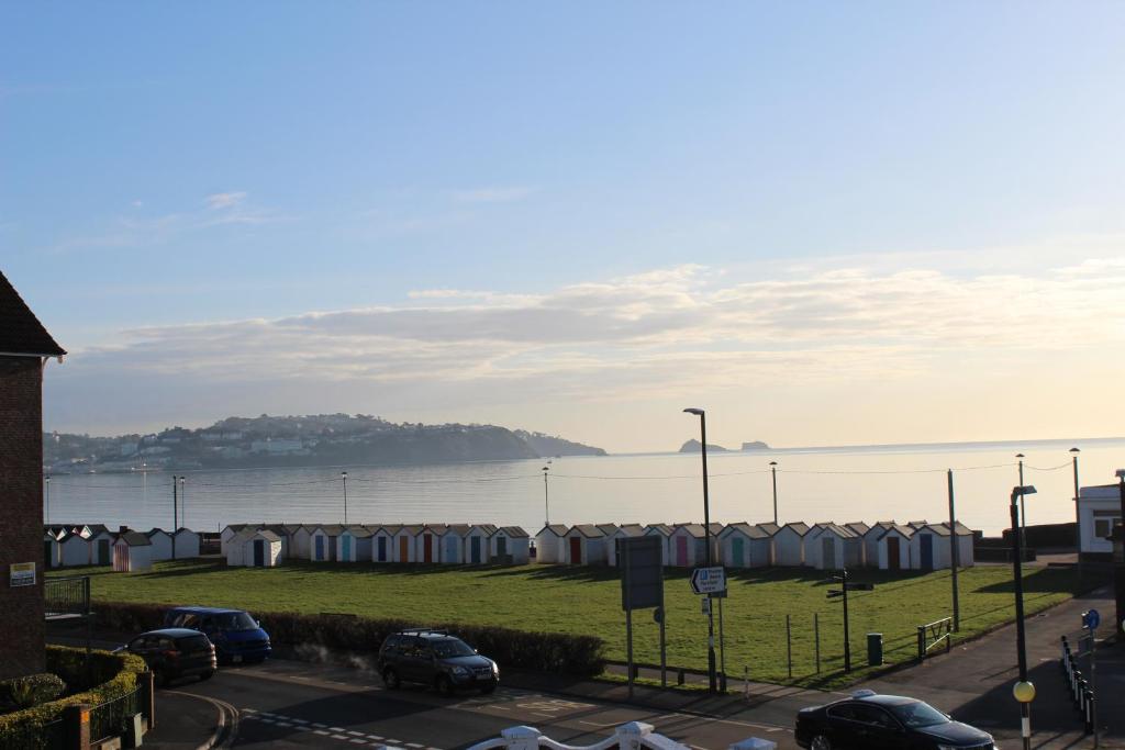 a parking lot with cars parked next to a body of water at Bayside in Paignton