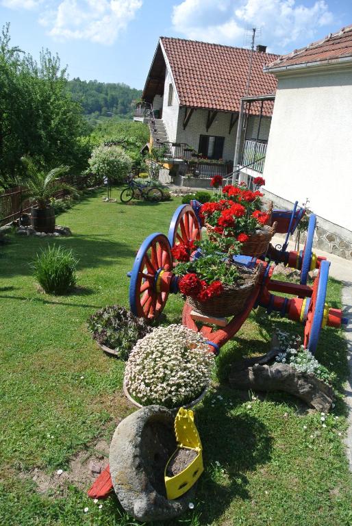 a garden with a wagon with flowers on it at Apartmani Mali Raj Rudnik in Rudnik