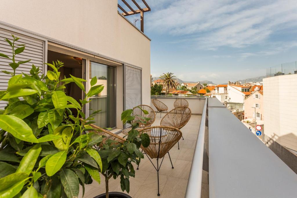 einen Balkon mit Stühlen und Pflanzen auf einem Gebäude in der Unterkunft Perla Apartmani Split in Split