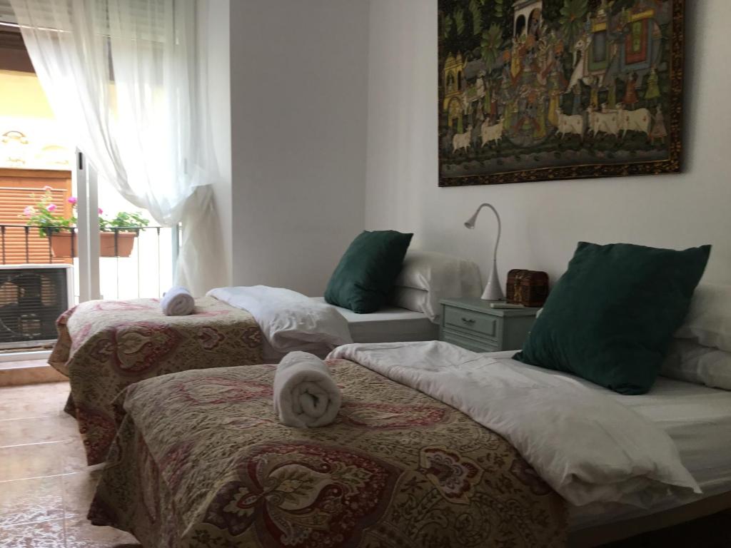 a room with two beds with towels on them at San José Guest House in Granada
