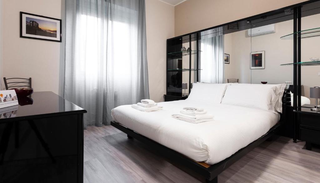 a bedroom with a large white bed with a black headboard at Italianway-Petrocchi 48 in Milan